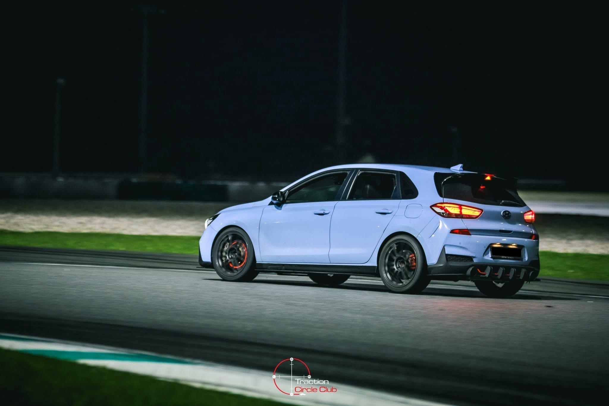 Rear three-quarter under floodlights, brake lights lit