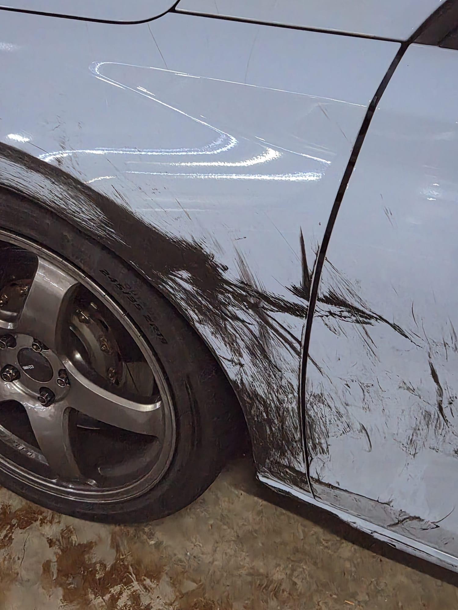 Rear door and fender scrape detail over the rear wheel