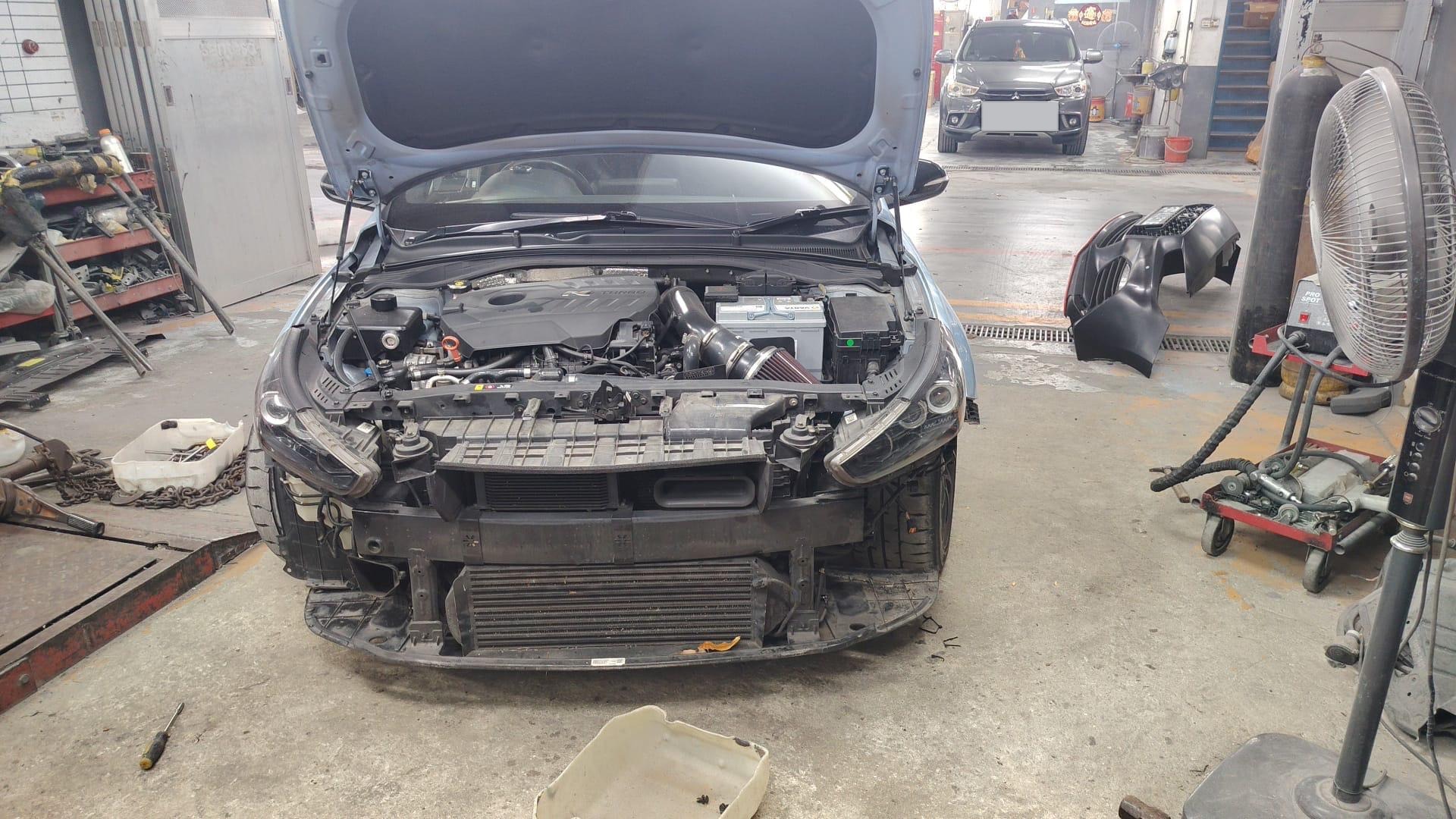 Front end stripped, hood up, intercooler and intake bare, headlights loose